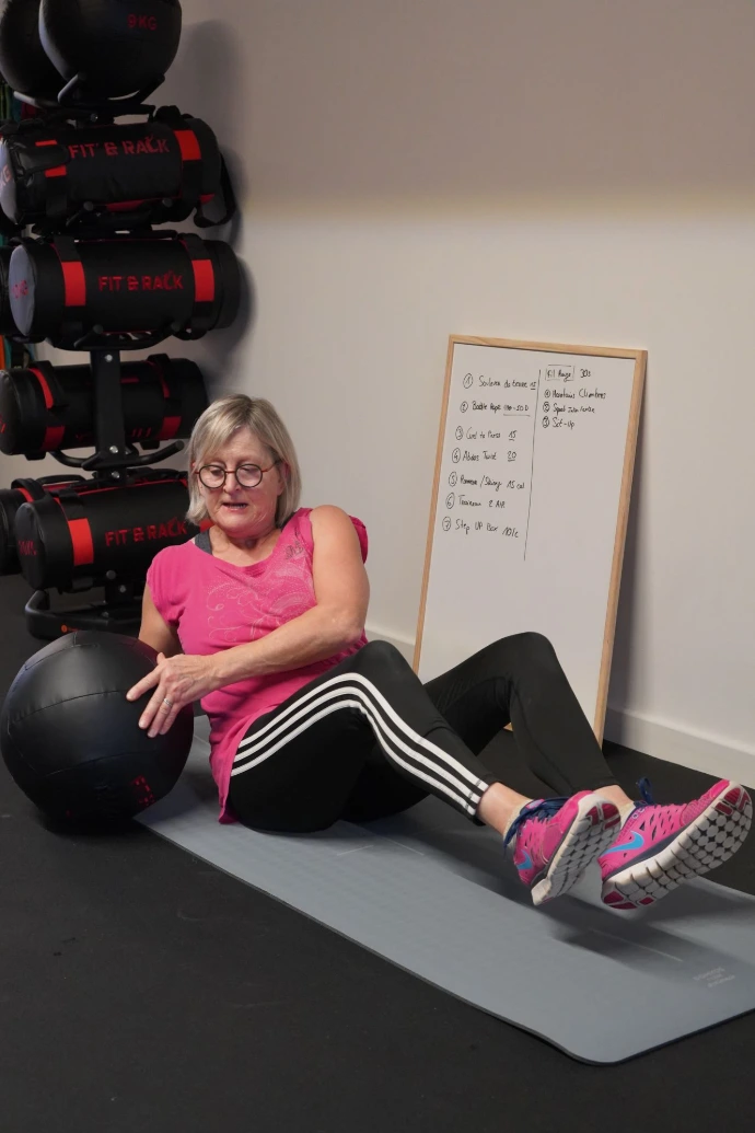 Personne âgée sur un exercice abdos Personne âgée qui réalise des abdos twists chez BPM Studio