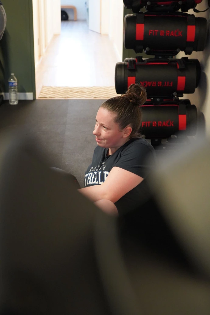 Sportive qui réalise des abdos twists Jeune sportive qui réalise des abdos twists. La photo est prise à travers le rameur de BPM Studio